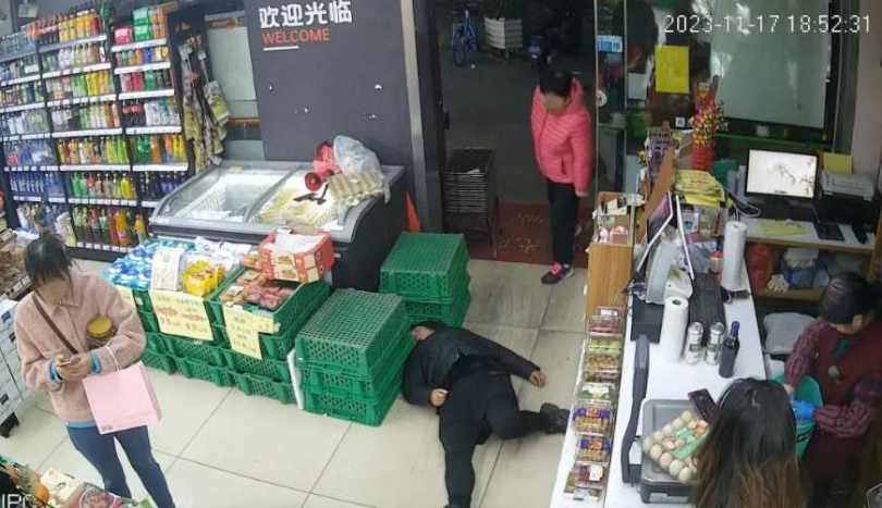 監控顯示,女子倒地後店員未撥打急救電話,只傳遞抹布協助清理嘔吐物。(圖/監視器畫面)