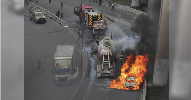 墨西哥城高速公路橋下一輛油罐車爆炸現場附近,一輛汽車燃燒。(圖/達志/美聯社)