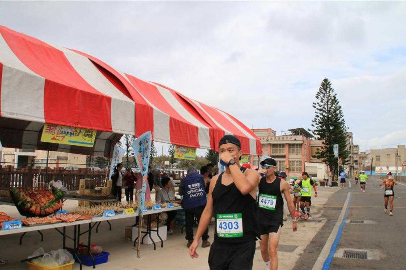 「菊島澎湖跨海馬拉松」，今年把痛風海鮮默默改移到第3站補給站後，大部分跑者只想補充水分，停下來吃幾口的不多。（圖／中國時報許逸民攝）