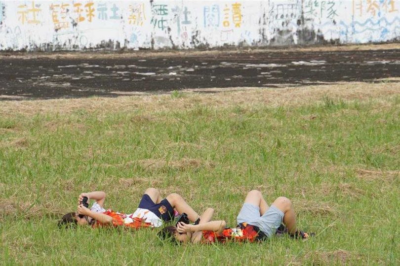 墾管處18日下午在滿州國中舉辦賞鷹活動，小朋友躺在草地上賞鷹。（圖／中國時報羅琦文攝）
