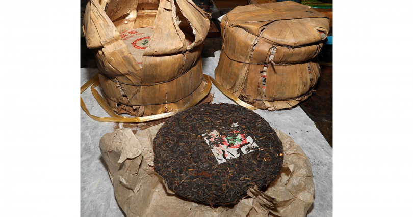 周君帶來的7542普洱七子餅茶拆開竹篾包裝與茶票紙。（圖／吳德亮攝）