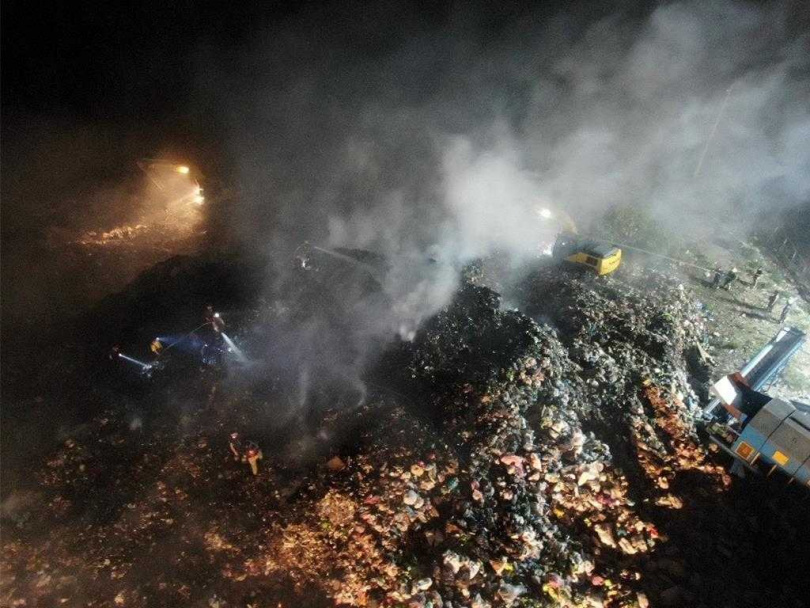 名間鄉垃圾山22日下午起火燃燒，晚間8時派怪手挖開垃圾讓沼氣散逸，進行殘火處理。（圖／南投縣政府提供）