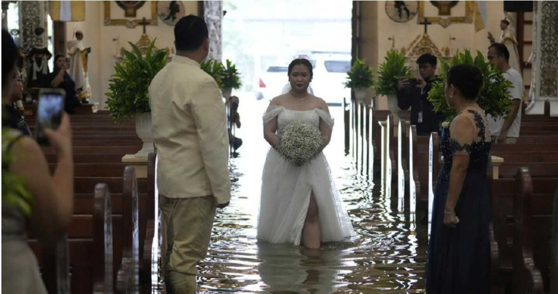 新娘涉水進入教堂，婚紗尾擺漂浮在積水中，展現愛情跨越困境的決心。
