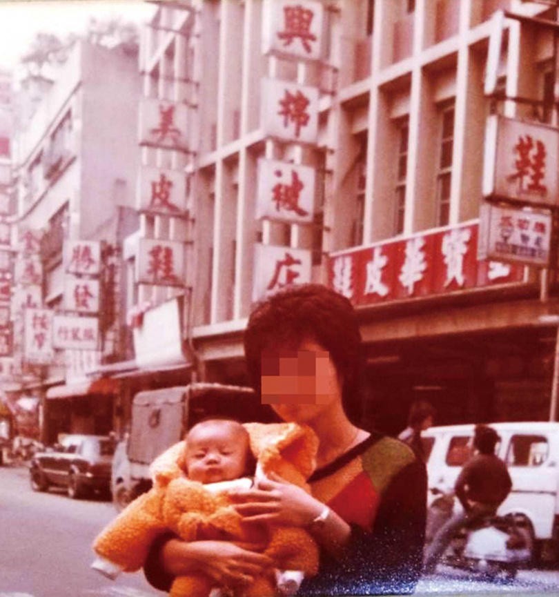 早期陳家從事棉被買賣,圖為陳媽媽懷抱著陳泰源在饒河街《隆興棉被店》2號店前合影。(圖/讀者提供)