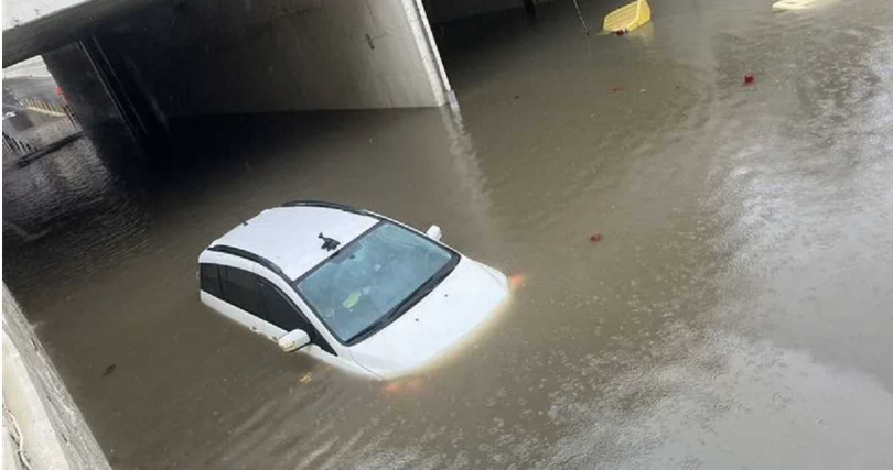 桃園市平鎮區的環南地下道因大雨慘變游泳池,一輛白色轎車突拋錨,險些遭滅頂。(圖/翻攝畫面)
