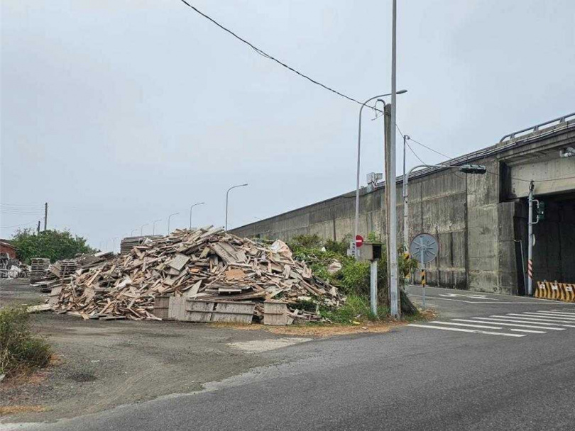 台61線公路下方堆置的模板恐會被強風吹到路面影響交通，居民通知區公所派員處理。（圖／民眾提供）