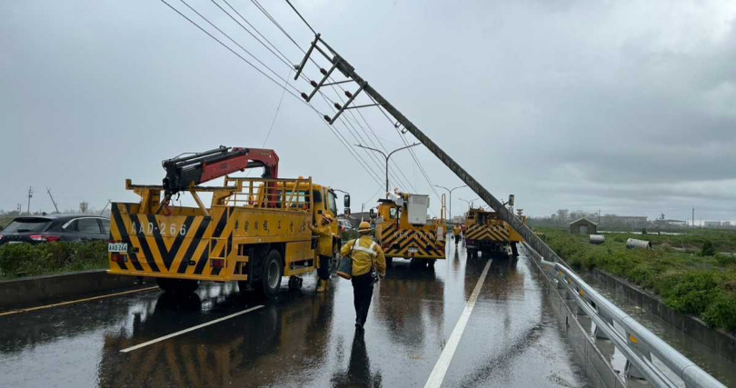 台電搶修人員頂著烈日與雨勢，合力吊掛近1噸重的新電桿，搶修場面緊張有序。（圖片提供／台電）