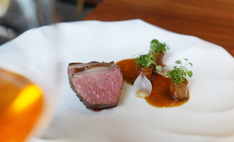 主餐「羊鞍 珍珠洋蔥 孜然」沒有過重腥羶味，亦可加價600元選擇以鹹鮮的「豆豉小魚」發想的主餐「和牛 丁香魚 豆豉」。（圖／魏妤靜攝）