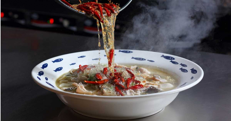 每份酸菜魚分別會再沖入辣椒、白芝麻、蒜末特製的熱油，爆出誘人香氣。（圖／刁民酸菜魚提供）