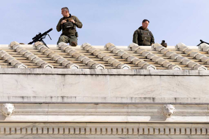 狙擊手於城市戰區環境中持槍埋伏,類似新聞所指富人參與「狙擊旅遊」的場景重現。