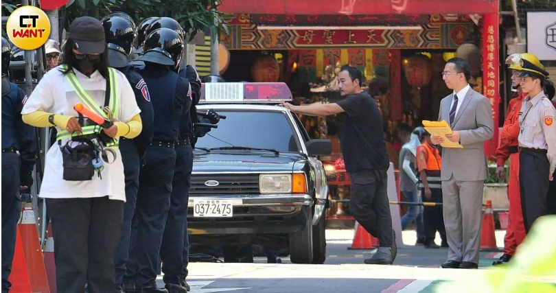 現場停著警車還有許多身穿舊式警察制服的臨演,打造出八〇年代感。(圖/本刊攝影組)