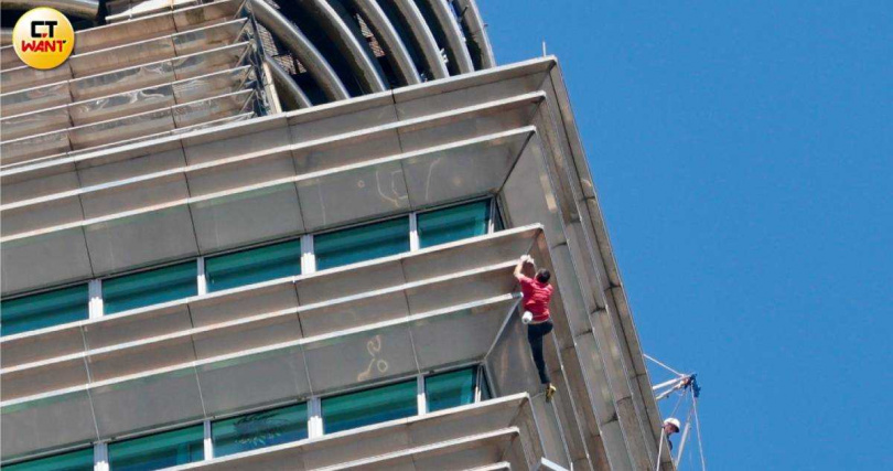 霍諾德挑戰徒手攀登台北101成功登頂，向下方揮手致意並自拍留念。（圖／黃耀徵攝）