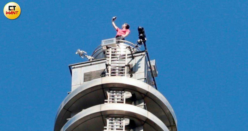 霍諾德挑戰徒手攀登台北101成功登頂，向下方揮手致意並自拍留念。（圖／黃耀徵攝）