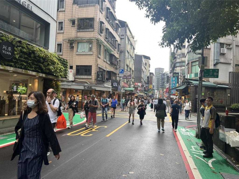 台北永康商圈10日首度試辦封街「漫步區」，起初不少遊客並未知悉封街一事，仍等待紅綠燈過馬路，後人潮逐漸往馬路上移動。（圖／中國時報張珈瑄攝）