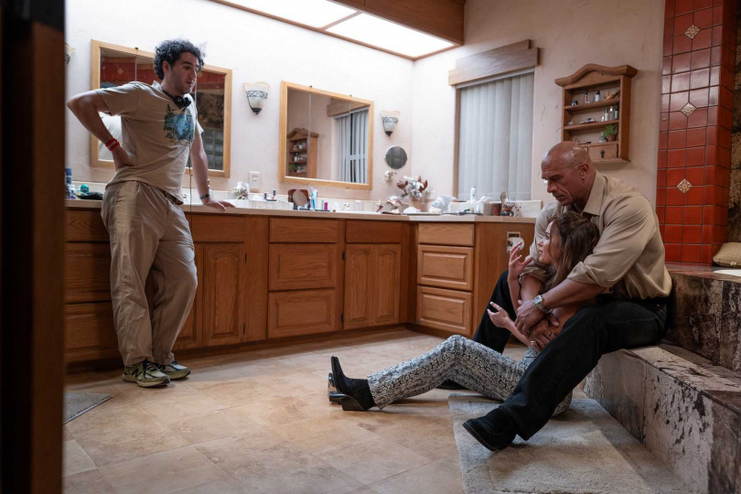 《重擊人生》導演班尼沙夫戴（左）在拍攝現場與巨石強森（右後）跟艾蜜莉布朗。（右前）討論演出方式。（圖／采昌提供）