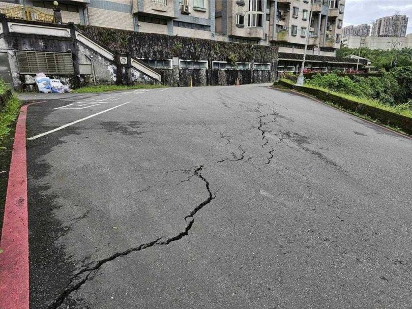 今天上午汐止伯爵街發生地面龜裂傾斜的狀況，目前已由警方前往設置封鎖線雙向管制並實施交通疏導，另外也通知區公所派廠商前往處理。（圖／翻攝畫面）