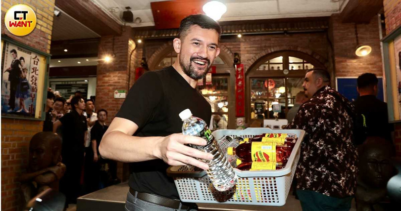 輝達黃仁勳兒子黃勝斌（Spencer Huang）在「兆元宴」現場，發送食品與飲料予守候的民眾。（圖／黃耀徵攝）