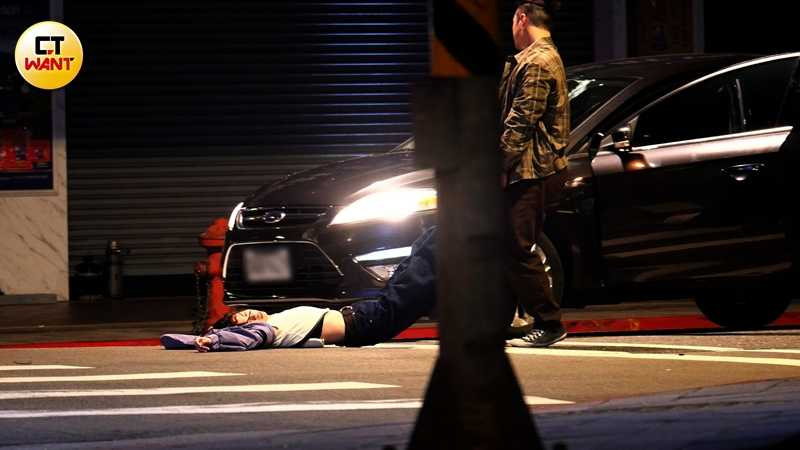 駕車演員下車走向躺在地上的馬士媛,慢慢地蹲下身體,雙手抓住她的雙腿拖行到車子旁邊。(圖/本刊攝影組)
