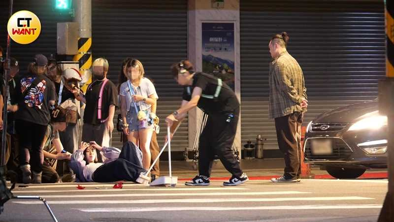 馬士媛躺在地上就位時,特技演員再度上前協助並指導動作。(圖/本刊攝影組)