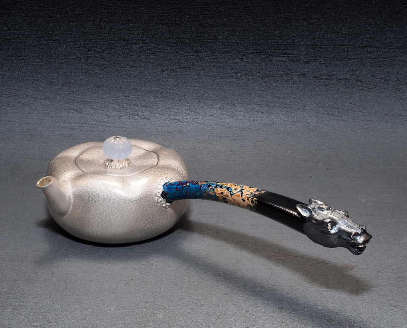 在漆藝流暢的單柄側把尾端鑲嵌純銀馬首的「留芳」瀹茶壺。（圖／吳德亮攝影）