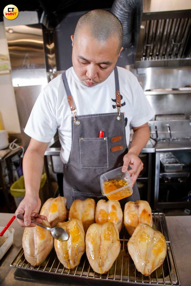 主理人Louis為烤雞刷上黑蒜風味油、讓香氣滲入皮肉之間，這是以高溫及中高溫油炸，分次取蒜頭焦香與甜香，再與烤雞油脂一起煉製而成。（圖／趙文彬攝）