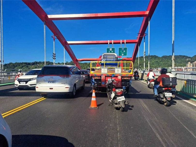 關渡橋2日上午發生聯結車與轎車擦撞意外，占用2線車道，造成後方車流嚴重回堵。（圖／翻攝畫面）