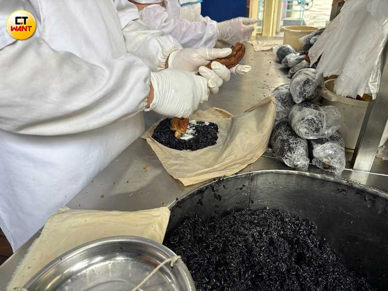 芳婆糕糰店招牌的黑米飯糰，在烏亮的糯米中包裹著酥脆的油條、鹹香的肉鬆和特製滷蛋，將甜鹹風味完美融合。（圖╱王若攝）