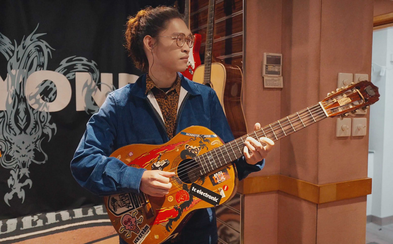 麋先生喆安試彈黃家駒的吉他。（圖／相信音樂提供）