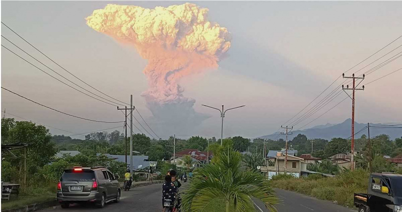 東努沙登加拉省居民遠眺勒沃托比火山噴發景象，天空被濃煙與火山灰籠罩。