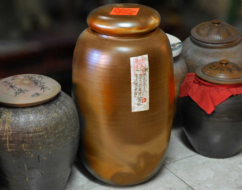 左右兩旁為早年留下的老陶甕作為茶倉，中為陶藝家廖玉瑩柴燒的大茶倉。（圖／吳德亮攝）