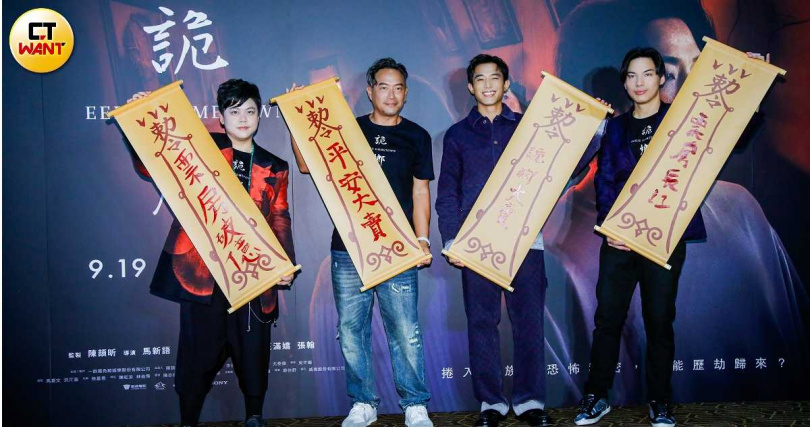 導演馬新語、監製陳頡昕,及主演初孟軒、張翰拿起用紅色書法字寫上「票房大賣」的大型符咒合影。(圖/趙文彬攝)