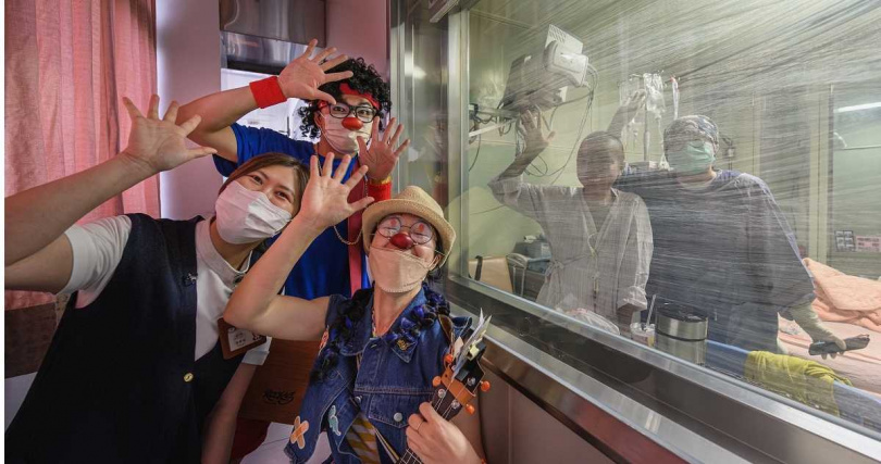 就算隔著玻璃，紅鼻子醫生也能和在隔離病房內的病童互動，為孩子表演，帶來歡笑。（圖／紅鼻子關懷小丑協會提供）