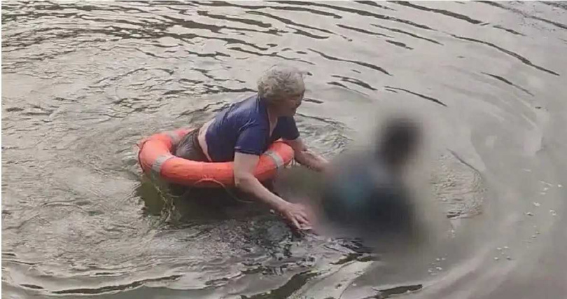 71歲的劉德芳聽見有人落水後,立刻攜帶救生圈跳入河中,歷經約20分鐘救援,成功協助將男子平安救上岸。