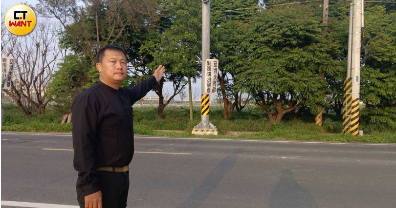 文史工作者洪建興指著抗議大旗,疾呼芳苑地區已有監獄擴建與紙廠汙染等鄰避設施,如今連火葬場也來湊一腳。(圖/顏瑋辰攝)