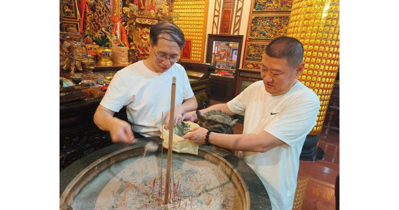 楊飛鴻（左）與洲美三王宮主委林富家於香爐前焚香領旨，親手恭迎三王公香灰，象徵正式承接祖宮神意與法脈傳承（圖／洲美三王宮提供）。
