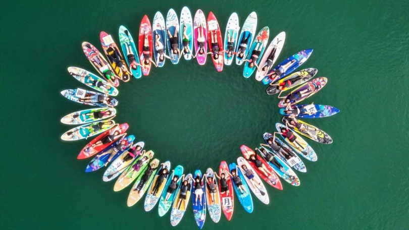 SUP立槳迎曙光活動，菁英們在湖面上划槳並肩前行排出「太陽花」隊型，不僅是對體力與協調的挑戰，更象徵業務團隊齊心協力推動業績與人力。（圖／全球人壽提供）