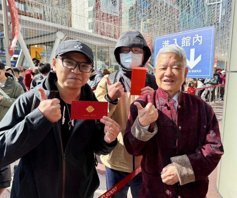 SOGO行政總經理杜金森（右）發紅包給排隊第一、二名的民眾。（圖／SOGO提供）