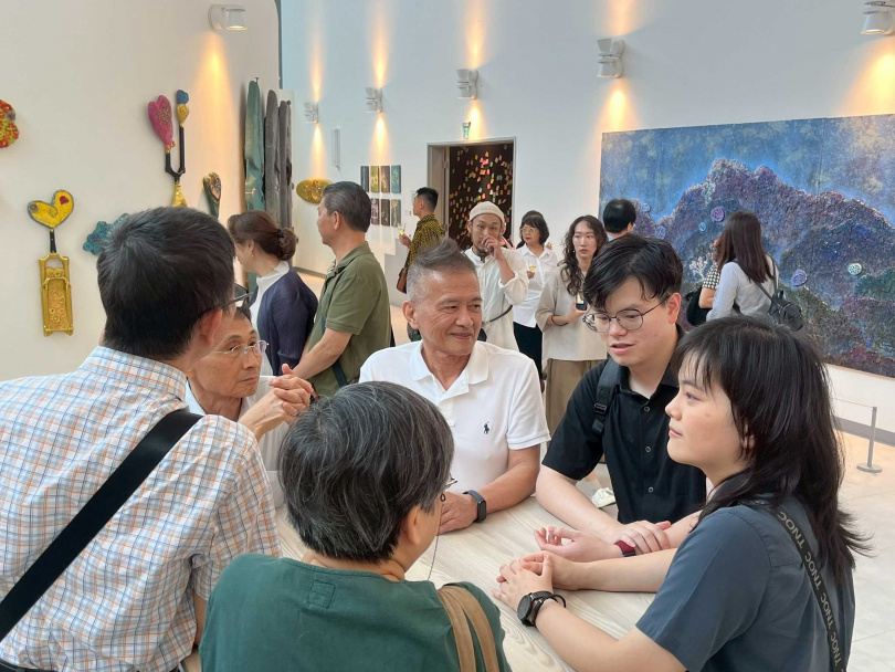 現場氣氛熱絡,藝術家曾英棟(白衣者)與嘉賓相談甚歡。(圖/甘樂阿舍美術館提供)