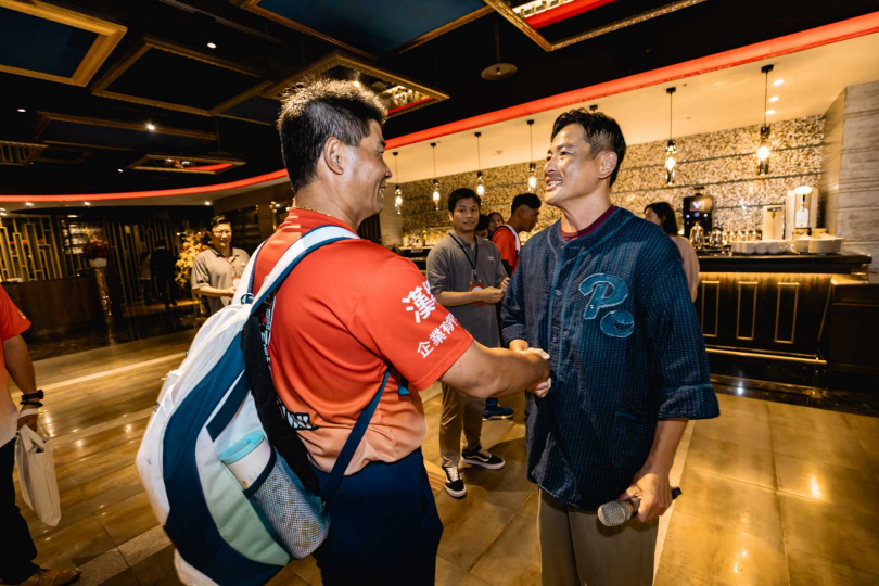 江宏恩（右）在慶功宴上和東園國小少棒總教練賴敏男相談甚歡。（美福、台北市政府提供）