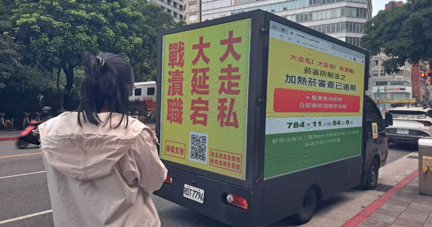 「支持政府即刻徵收加熱菸稅捐」宣傳車在總統府附近掃街，一名癌症病患家屬，拿起手機掃碼表達對活動的支持。（圖／讀者提供）