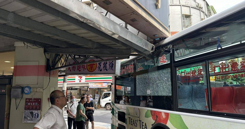 三重客運學生專車9日在蘆洲民族路轉彎時不慎撞到招牌，使車輛進退不得。（圖／蘆洲警分局提供）