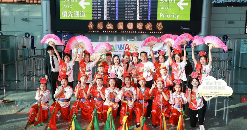 金門中正國小鼓吹隊受邀代表臺灣赴捷克參加「使館節」國際交流，於桃園機場第二航廈出境大廳熱鬧合影，期盼以傳統嗩吶與哨角樂聲，讓世界看見金門、認識臺灣。（圖／財團法人昇恒昌基金會提供）