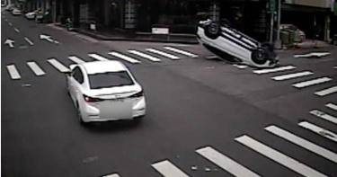 台中市北區一輛BMW休旅車遭馬自達轎車擦撞，一度側翻後整車翻覆，四輪朝天於路中央，所幸駕駛僅左手擦傷無大礙。（圖／讀者提供）
