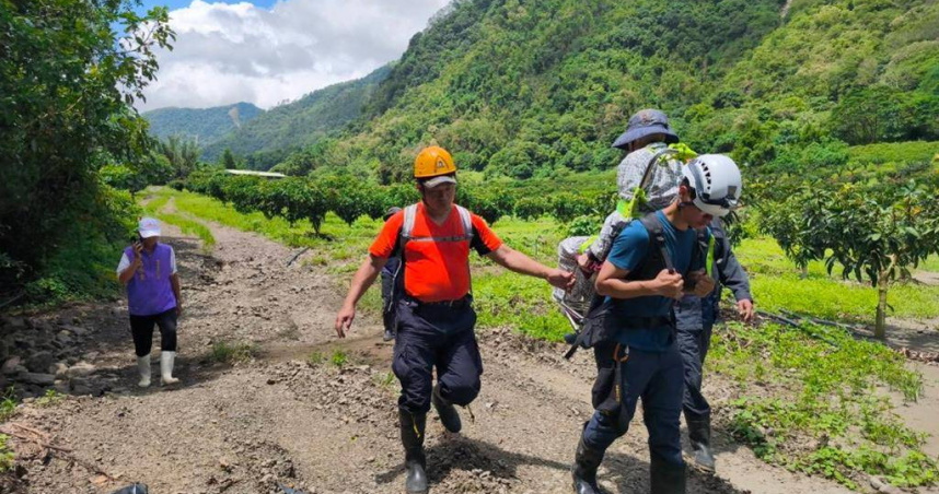 高雄桃源區因7月28日豪雨引發多處道路坍方與設施損壞，導致聯外道路中斷，許多山區居民受困無法下山，其中95歲章姓老翁因行動不便被困家中超過10天，兒子無力處理緊急求助後，今（12）日上午由消防局聯同復興部落在地居民及中華戶外探險協會雲豹工作隊成員江維明，徒步挺進崎嶇山路進行救援。（圖／高雄市消防局提供）
