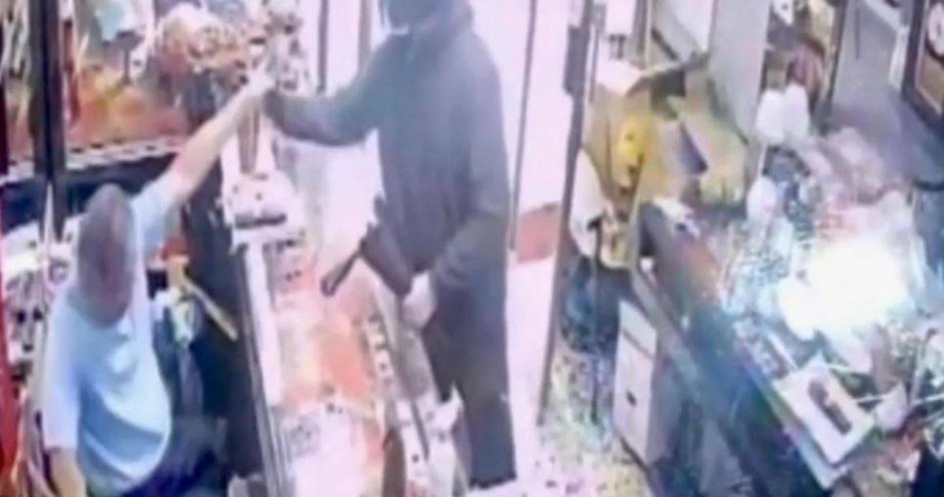 犯嫌持辣椒水攻擊銀樓老闆，隨後持錘擊破展示櫃盜走13兩黃金。（圖／翻攝畫面）