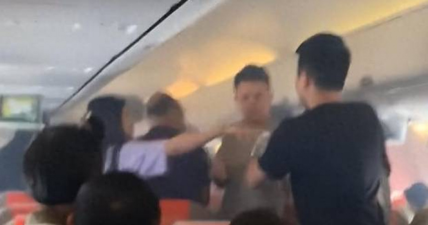 大陸上海航空FM9449航班日前在飛行過程中，因旅客攜帶的行動電源突然冒煙，旅客使用礦泉水接力協助撲救。（圖／翻攝自微博）