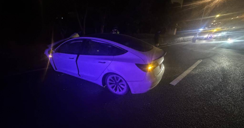 特斯拉轎車疑因駕駛恍神自撞內側護欄，失控衝入南崁交流道匝道，駕駛頭部受傷送醫。（圖／翻攝畫面）