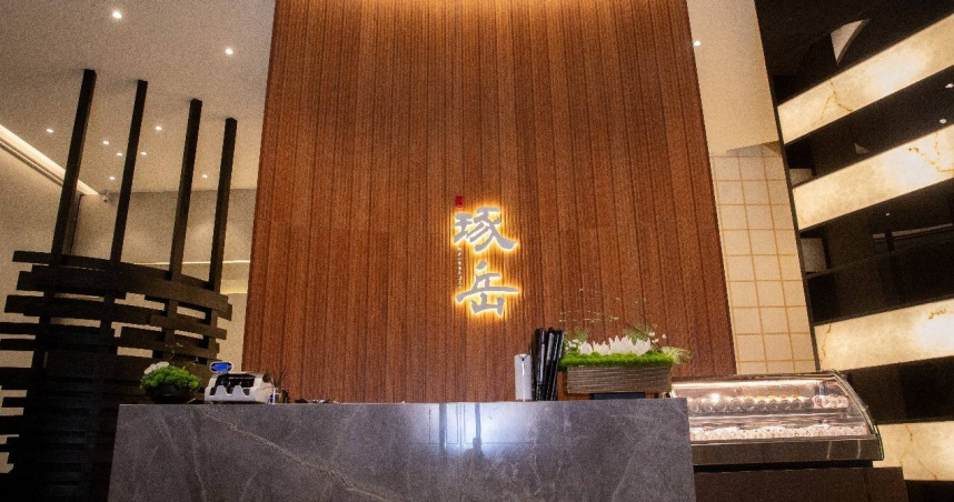 「琢岳」外觀設計展現當代日式語彙，簡約的木紋格柵搭配灰白色磁磚，在夜晚透過線燈與星芒燈的點綴，營造出溫暖且具層次感的視覺享受（圖／CTWANT攝）。