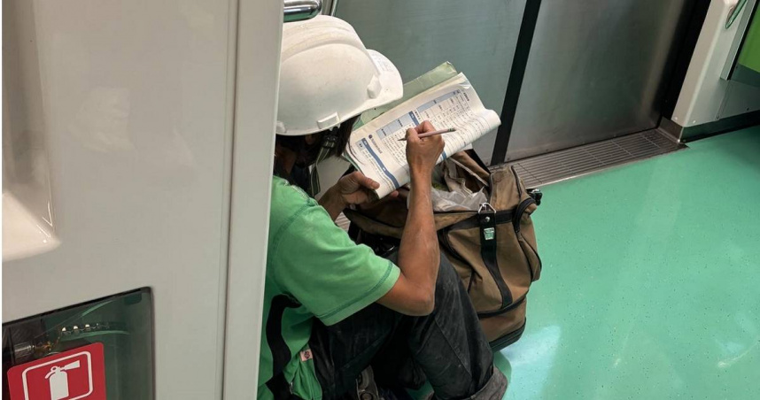 女工人蹲車廂地板看書。（圖／翻攝李威立臉書）