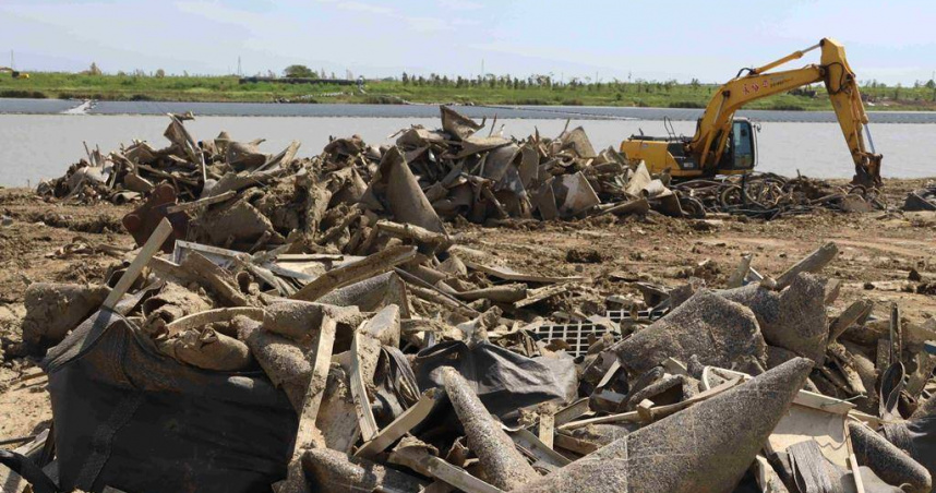 嘉義縣義竹鄉新庄滯洪池廢棄光電設施量體龐大，目前業者仍在清理中。（圖／中國時報呂妍庭攝）